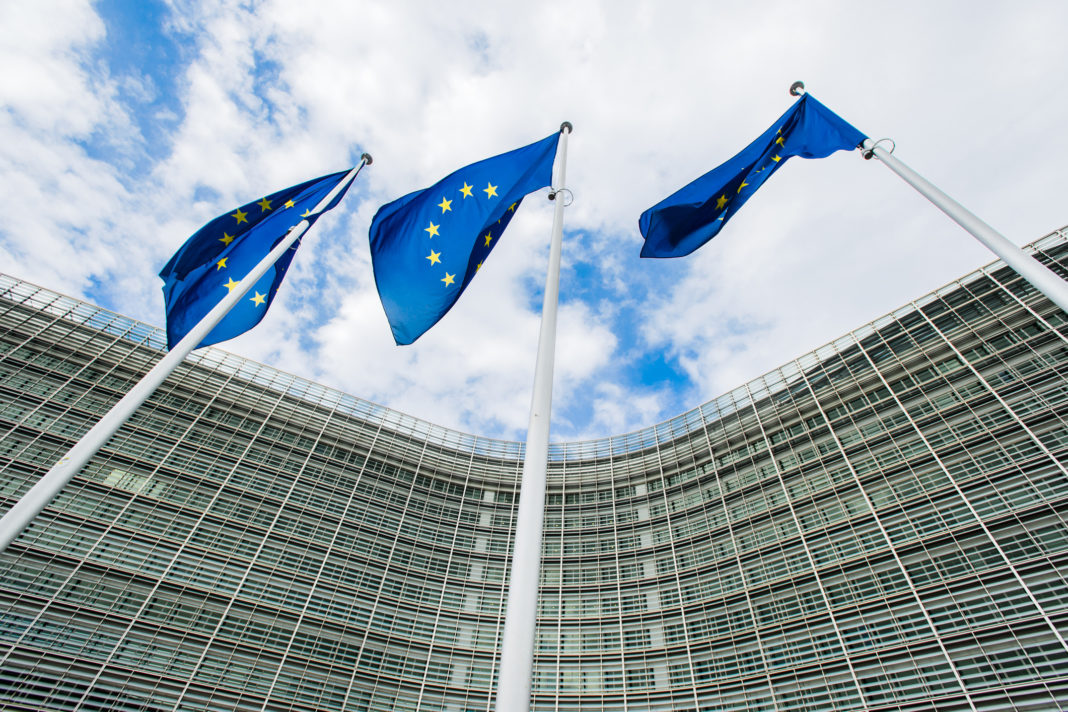 flags of the European Union against the background of the European Commission building Berlaymont in Brussels, Belgium comision europea