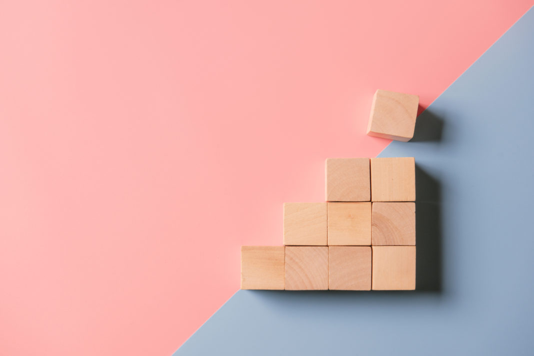 Concept growth success process, Close up wood block stacking as step stair on paper blue background.