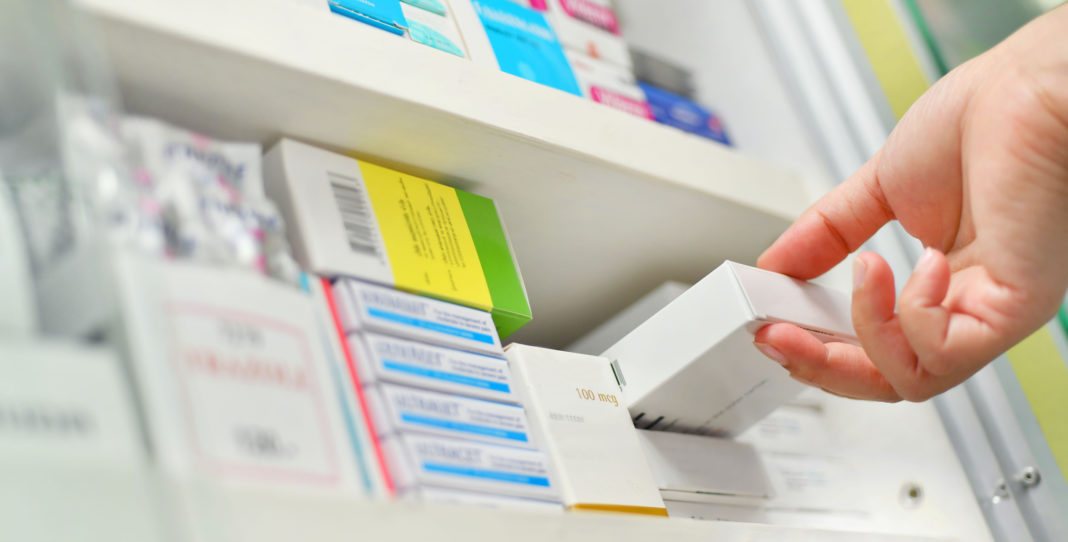 Closeup pharmacist hand holding medicine box abastecimiento