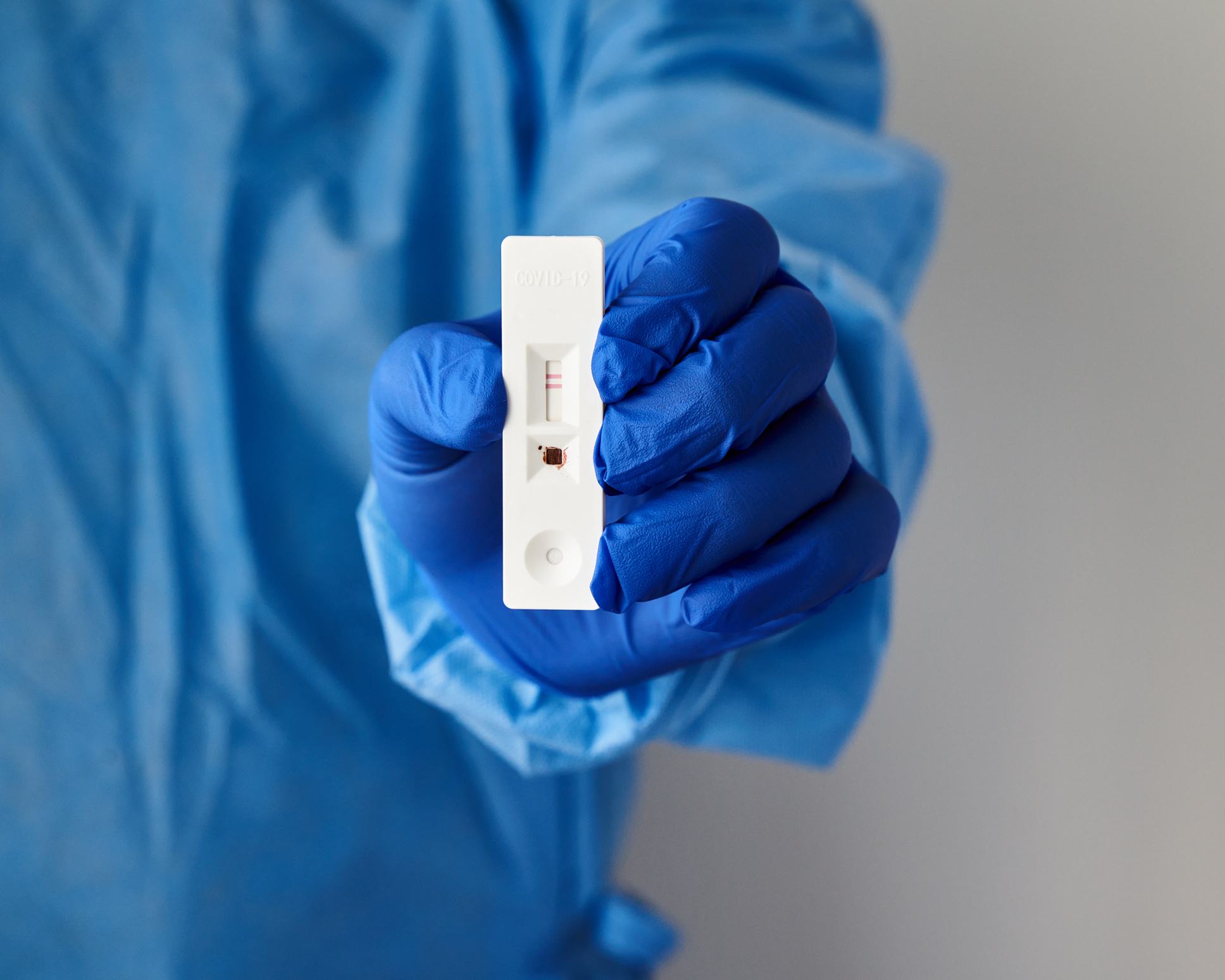 Unrecognizable doctor holds in hand positive test for antibodies to covid-19 virus