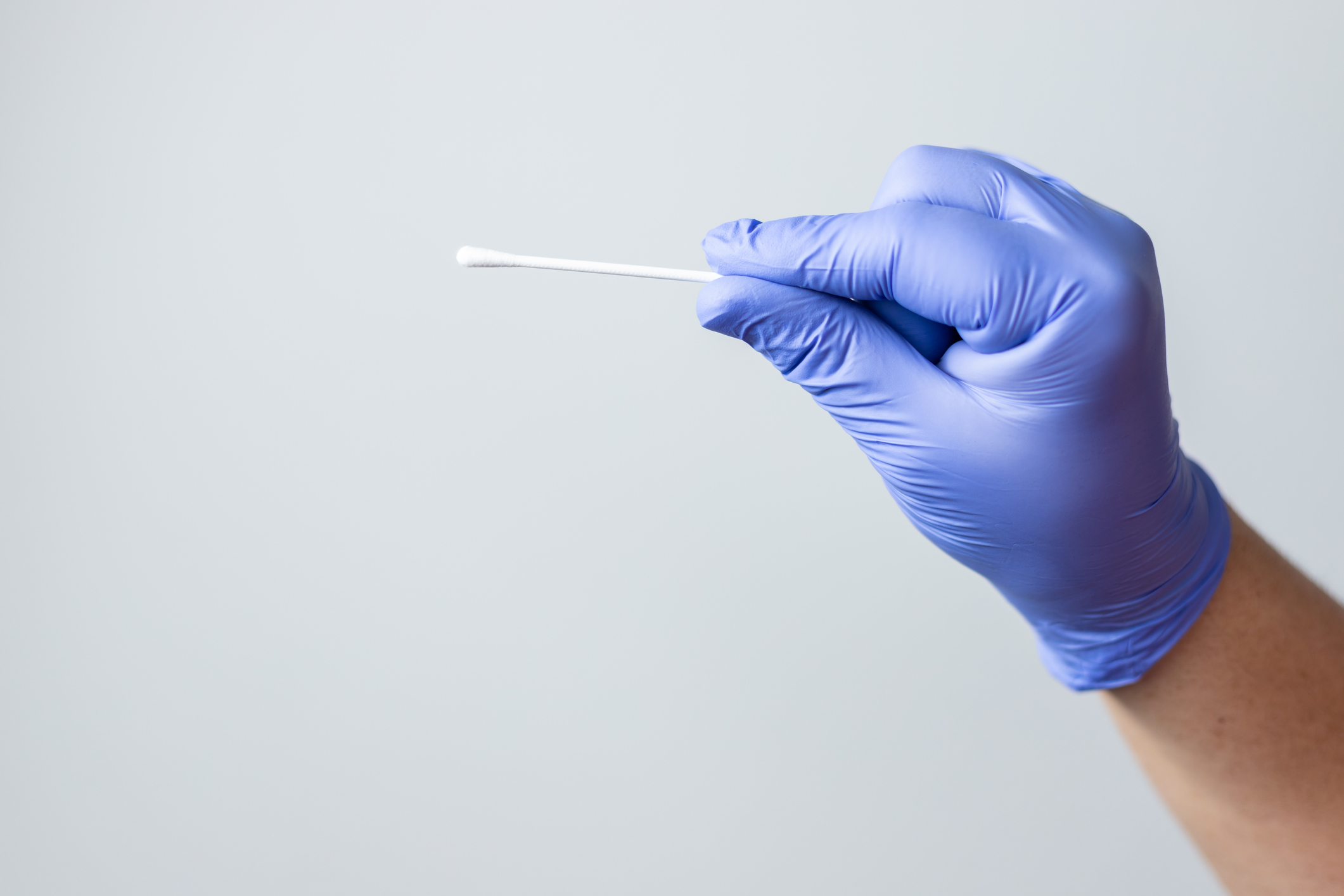 blue gloved hand holding coronavirus nasal test stick, or covid-19. Coronavirus test concept. test