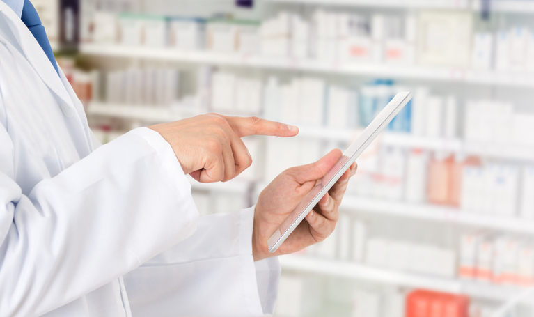 Pharmacist making notes on a digital tablet
